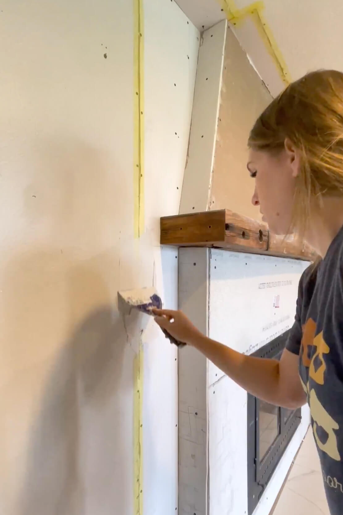 Finishing drywall around a fireplace.